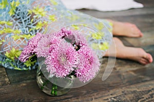 Home made floral decoration on a dark background. Beautiful chrysanthemum in a vase. Purple chrysanthemum, pink flowers on a shelf