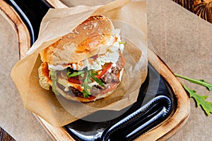 Home made hamburger with beef, onion, tomato, lettuce and cheese. Fresh burger closeup on wooden rustic table.