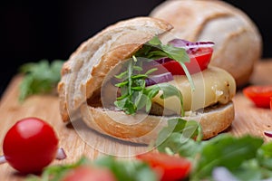 Home made hamburger with beef, onion, tomato, lettuce and cheese. Fresh burger closeup on wooden rustic table with fresh