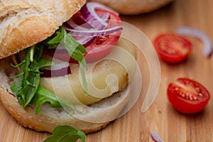 Home made hamburger with beef, onion, tomato, lettuce and cheese. Fresh burger closeup on wooden rustic table with fresh