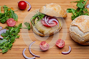 Home made hamburger with beef, onion, tomato, lettuce and cheese. Fresh burger closeup on wooden rustic table with fresh