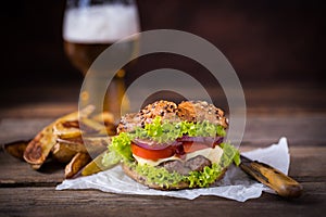 Home made hamburger with green salad on brown wooden background