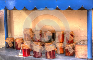 Home made jams and preserves for sale in pots with labels in colourful HDR