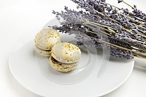 Home-made macaroons on a white plate with lavender