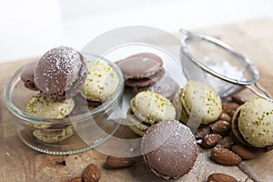 Home-made macaroons on wooden board with power sugar