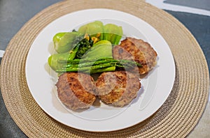 Home made minced meat cutlets served with green vegetables. Healthy food. Meatballs on a white plate with veggies