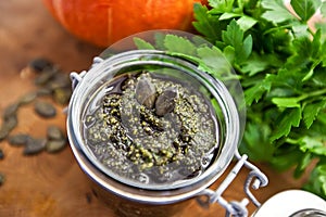 Home made pumpkin seeds pesto sauce with walnuts, olive oil, salt, greens and spices in a jar, vegan, vegetarian healthy