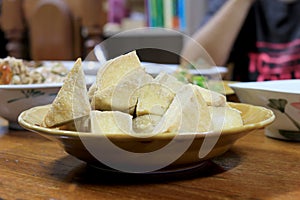 Home made of snack and dessert, Chinese Traditional Deep Fried Tofu or Fried Bean Curd Served in dish on wooden table