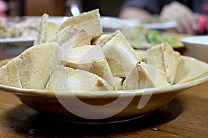 Home made of snack and dessert, Chinese Traditional Deep Fried Tofu or Fried Bean Curd Served in dish on wooden table