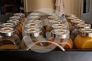 Home made spice jars lined up in a black box. Country kitchen crafts and hobbies