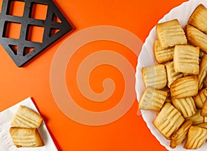 home made square biscuits put in white dish on orange background top