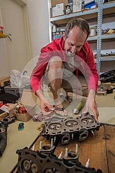 A home mechanic assembling a V6 cylinder heads