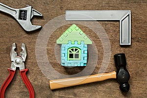 Home model object with toy equipment tool on wood background photo