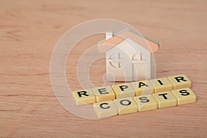 Home model with text REPAIR COSTS.Housing cost concept