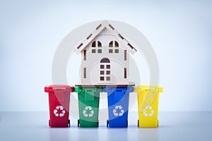 Home model on trush bins over gray background. Eco. photo