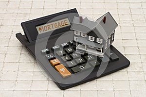 Home Mortgage, A gray house and calculator on stone background