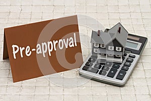 Home Mortgage Pre-approval, A gray house, brown card and calculator on stone background photo