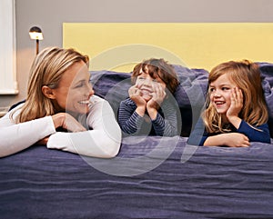 Home, mother and kids in bed with love, support and bonding together with a smile. Happy, family and children with mom
