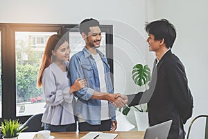 home moving and relocation concept. Happy asian couple shaking hands with real estate agent