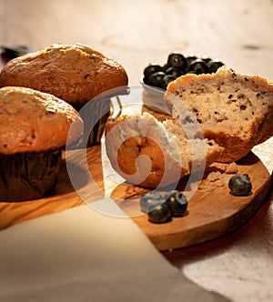 Home nade muffins with blueberries on wooden chopping board. photo
