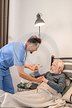 In-home nurse assisting the patient into a sitting position