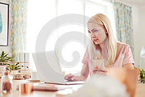 Home office, busy young woman working on laptop