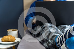 Home office concept - man working from his bed with breakfast