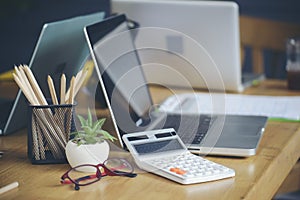 Home Office Desk Concept.Laptop, summary report, chart, and calculator for accountant or bookkeeper plan annual budget and tax.