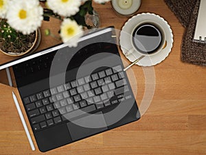 Home office desk with laptop, coffee cup, copy space and flower vase