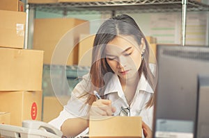 Home office and startup of small business owner businesswoman, delivery shipping package with parcels,cardboard box and writing