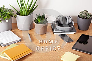 Home office text desk with tablet computer smartphone notebook houseplants, working space at home