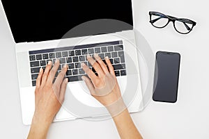 Home office workspace mockup. Laptop with blank screen, hands and accessories on white