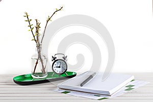 Home office workspace mockup with notebook, pen, alarm clock, plant potted and accessories on white wood desk background, copy