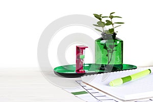 Home office workspace mockup with notebook, pen, hourglass, plant in wooden potted and accessories on white wood desk background,