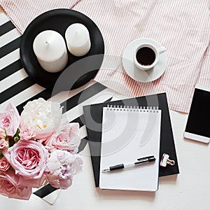 Home office workspace. Notebook with copyspace. Beauty concept. Woman fashion accessories, phone and coffee on bed background.