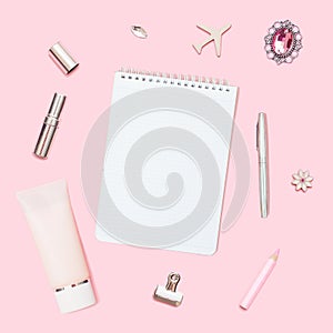 Home office workspace. Notebook with copyspace. Flat lay, social media. Woman fashion accessories and flowers on pink background.