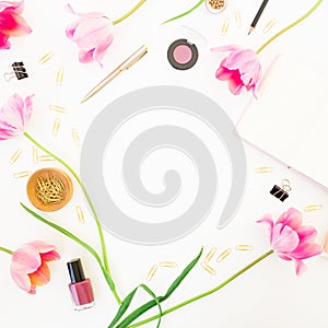 Home office workspace with notebook, cosmetics, pink tulips and accessories on white background. Round frame. Flat lay, top view.