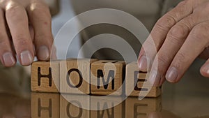 Home, old man making word of wooden cubes, missing home, motherland, close-up
