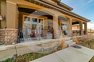 Home with open front porch featuring arch columns metal railings and stone wall