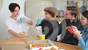 Home party. Friends spending time together having fun laughing communicating at home. Happy diverse group eating pizza