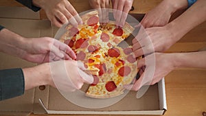 Home party. Top view male female hands taking slices of pizza from food delivery open box. Group of hungry friends