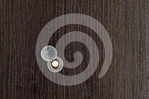 Home peephole with metal lid cover on brown wooden door