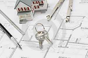 Home, Pencil, Ruler, Compass and Key Resting on House Plans