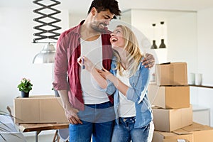Home, people, moving and real estate concept - happy couple having fun while moving in