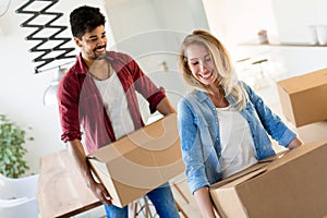 Home, people, moving and real estate concept - happy couple having fun while moving in