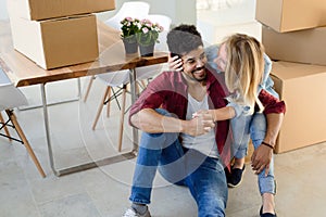 Home, people, moving and real estate concept - happy couple having fun while moving in