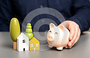 Home and a piggy bank. Budget and maintenance of buildings.