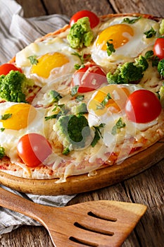 Home pizza with eggs, broccoli, tomatoes and greens close-up. vertical