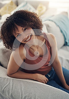 Home is the only place where I can recharge. an attractive young woman sitting alone on her sofa in the living room at