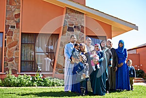 Home, portrait and family of muslim people, outside and house with smile for Eid celebration. Garden, lawn and islamic